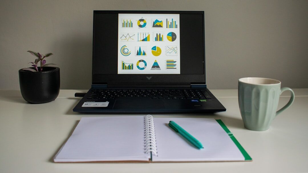 Open notebook with pen next to a coffee cup on a desk